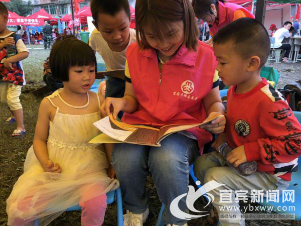幼教老师志愿者和孩子们一起读绘本。